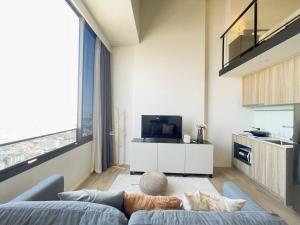 ein Wohnzimmer mit einem blauen Sofa und einem TV in der Unterkunft 2209 Duplex 高层景观公寓 BTS ON NUT in Bangkok