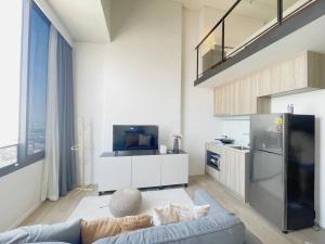 ein Wohnzimmer mit einem Sofa und einem Kühlschrank in der Unterkunft 2209 Duplex 高层景观公寓 BTS ON NUT in Bangkok