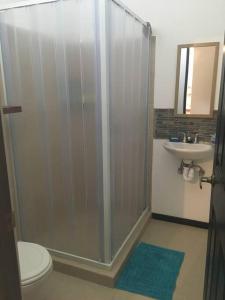 a bathroom with a shower and a toilet and a sink at Casa de playa, Bejuco Costa Rica in Bejuco