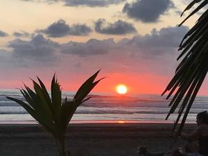 a person sitting on the beach watching the sunset at Casa de playa, Bejuco Costa Rica in Bejuco