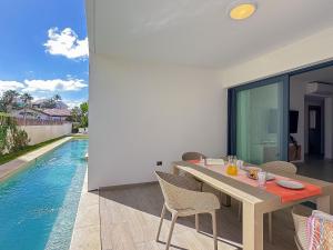 a dining room with a table and a swimming pool at Apto de 2 hab y 2 bañ swim up a pasos de la playa in Punta Cana