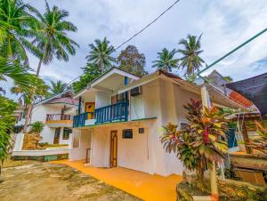 a house with palm trees in front of it at Czar's Place in Siquijor