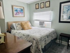 a small bedroom with a bed and a window at Mango Beach House in Lake Worth