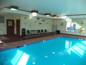 una gran piscina en una habitación con sillas y mesa en Holiday Inn Express La Junta, an IHG Hotel, en La Junta