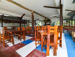 an empty restaurant with wooden tables and chairs at Czar's Place in Siquijor