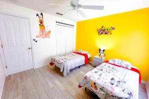 a bedroom with two beds and a yellow wall at *Home in davenport Cheerful 5-bedroom with pool in Davenport