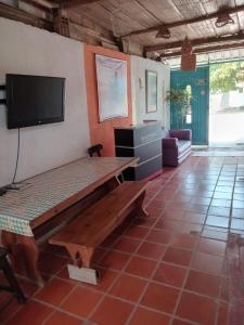 a living room with a wooden table and a flat screen tv at Hostal ROLLED in Villavieja