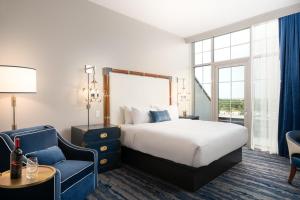 a hotel room with a bed and a blue chair at JW Marriott Savannah Plant Riverside District in Savannah