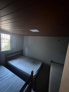Habitación pequeña con 2 camas y ventana en Casa beiramar Provetá IlhaGrande en Angra dos Reis