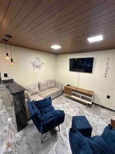 a living room with a couch and a tv at Casa beiramar Provetá IlhaGrande in Angra dos Reis