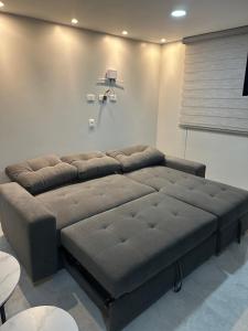 a large brown couch in a room with a window at Moderno apartamento primer piso in Dosquebradas