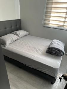 1 cama no hecha en una habitación con ventana en Moderno apartamento primer piso, en Dosquebradas
