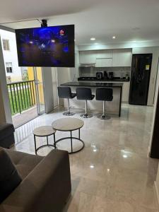 a living room with a couch and a kitchen with a tv at Moderno apartamento primer piso in Dosquebradas