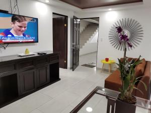 a living room with a tv on a wall at 935 Lodge San José in San José