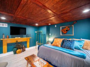 1 dormitorio con 1 cama con una guitarra en la pared en Rhythmic Escape, en Marietta