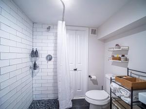 a white bathroom with a shower and a toilet at Rhythmic Escape in Marietta