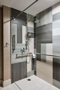 uma casa de banho com um chuveiro e uma porta de vidro em Omaha Marriott Downtown at the Capitol District em Omaha
