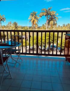 a balcony with a table and chairs and palm trees at Le Grey House in Saint-François