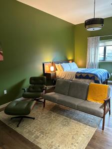 um quarto com uma cama, um sofá e cadeiras em VioletSuitesPDX em Portland