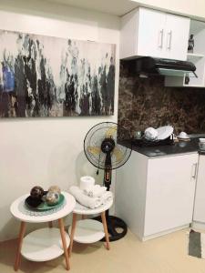 a kitchen with a table with a fan on it at Avida Atria Tower I Cozy Condo Great Location in Iloilo City