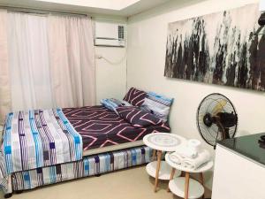 a small bedroom with a bed and a table at Avida Atria Tower I Cozy Condo Great Location in Iloilo City
