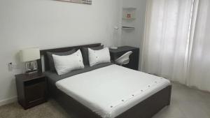 a bedroom with a large bed with white sheets and pillows at White-House in Kigali