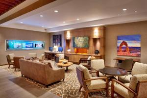 a lobby of a hotel with chairs and tables at SpringHill Suites by Marriott Moab in Moab