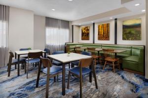 um restaurante com mesas e cadeiras e um sofá verde em Fairfield Inn Philadelphia Airport em Filadélfia