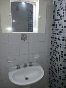 a white bathroom with a sink and a mirror at JOAQUINA in Ramallo