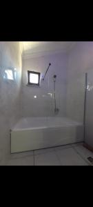 baño con bañera blanca y ventana en Celebi Home en Arnavutköy