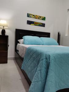 a bedroom with a bed with blue pillows at 935 Lodge San José in San José