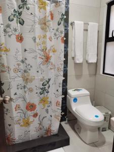 uma casa de banho com uma cortina de chuveiro e um WC. em 935 Lodge San José em San José