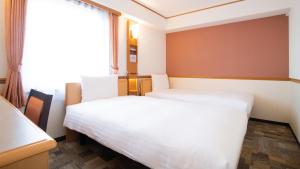 Habitación de hotel con 2 camas y ventana en Toyoko Inn Hokkaido Asahikawa Ekimae Ichijo dori, en Asahikawa