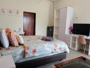 a bedroom with a bed and a flat screen tv at Mama Nings Beach Hotel in Sekongkang