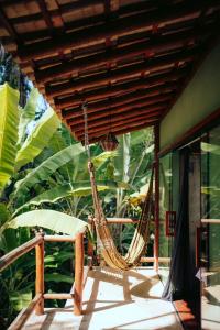- un hamac sur une terrasse couverte avec des arbres en arrière-plan dans l'établissement Boutique Beach Chalet, Luzimares, Serra Grande-BA, à Serra Grande