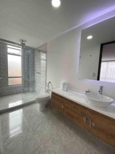 een badkamer met een wastafel, een toilet en een spiegel bij Armonía Casa Spa in Bogota