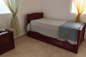 ein Schlafzimmer mit einem Bett, einer Kommode und einem Fenster in der Unterkunft Bright and cozy place to relax. in La Romana