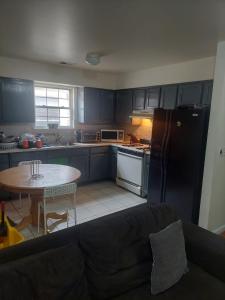 a kitchen with a black refrigerator and a table at Crystal Room 1 Guest House near 12mins to EWR airport / Prudential / NJIT / Penn station in Newark