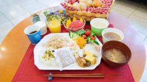 a table with a plate of food with rice and fruit at Toyoko Inn Hokkaido Asahikawa Ekimae Ichijo dori in Asahikawa