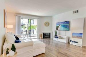 a living room with a white couch and a fireplace at Nautical 2 Bedroom in the of Heart Marina del Rey in Los Angeles