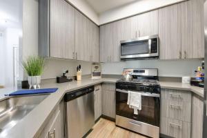 a kitchen with stainless steel appliances and wooden cabinets at Nautical 2 Bedroom in the of Heart Marina del Rey in Los Angeles