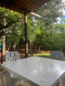 una mesa blanca y dos sillas sentadas bajo una pérgola en Pousada Recanto dos Sonhos, en Alto Paraíso de Goiás