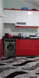 Celebi Home في Arnavutköy: مطبخ مع غسالة و دواليب حمراء