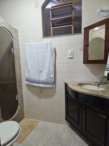 y baño con lavabo, espejo y aseo. en CAXU HOSTEL en Cachoeiro de Itapemirim