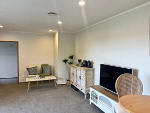 オークランドにあるPerfect living in Easternのリビングルーム(薄型テレビ、テーブル付)