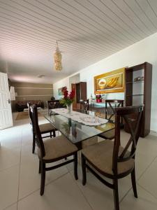 a dining room with a glass table and chairs at House Beach Canoa in Canoa Quebrada