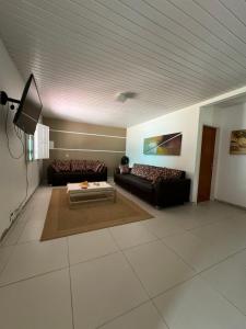 a living room with two couches and a tv at My House Canoa in Canoa Quebrada
