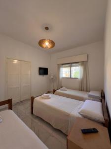 a bedroom with two beds and a television and a table at URBAN 483 in La Falda