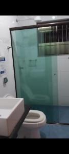 Un baño con un inodoro blanco y un lavabo. en Casa de Praia com Piscina em Peruíbe, en Peruíbe 16 fotos más