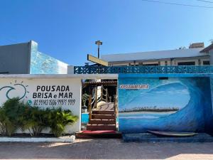 Un edificio con un dipinto di un'onda sopra di Pousada Brisa e Mar a Praia do Frances